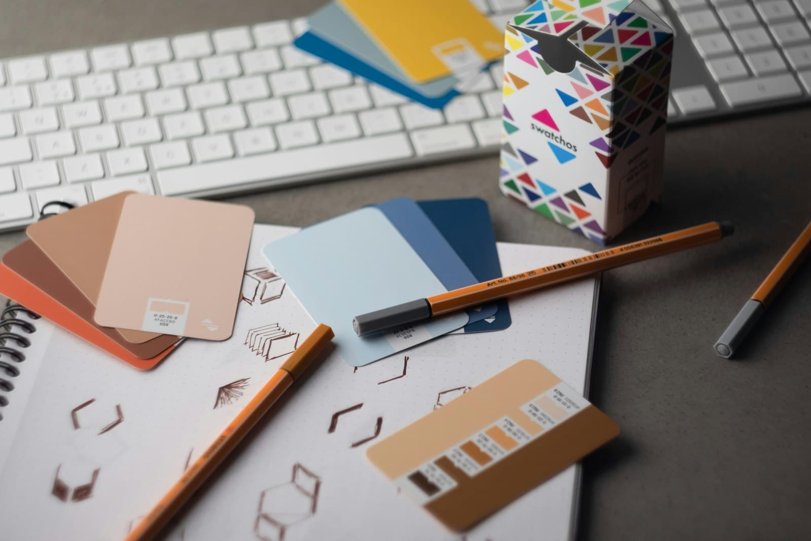 Color swatches, typography sketches, and design tools on a desk